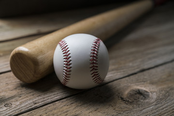 baseball and baseball bat on wooden table background, close up