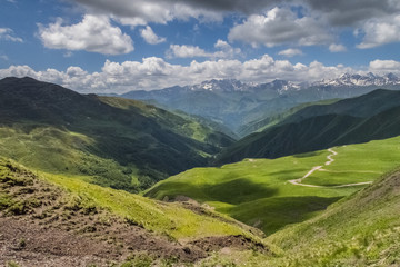 Fototapeta na wymiar Scenic view of Hevsureti, Georgia. Caucasus mountains on the background, green valley on the foregound. Hot summer day. Concept of clear ecosystem.