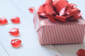 gift box with red bow and hearts on light background