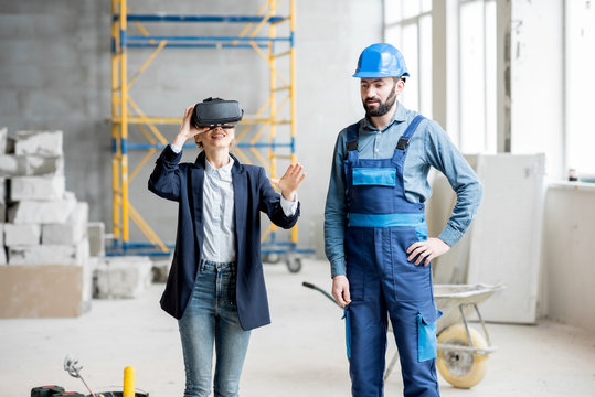 Woman client wearing VR glasses imagining future interior standing with builder at the construction site