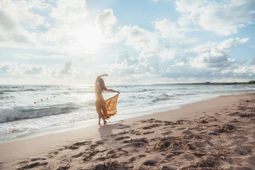 Fototapeta na wymiar Boho girl walking on the beach