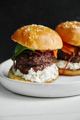 Burgers with grilled beef patties, cream cheese and spinach on classical bun.