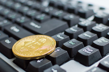 One golden bitcoin on keyboard. Digital cryptocurrency concept