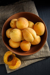 Apricots in bowl on linen and black slate stone