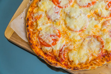 Slice of hot pizza large cheese lunch or dinner crust seafood meat topping sauce. with bell pepper vegetables delicious tasty fast food italian traditional on board table classic in side view .