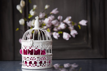 white cage with flower inside on the table