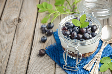 Healthy dessert with homemade granola, yogurt and blueberries, selective focus, copy space.