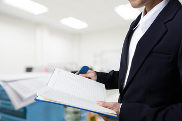 Businessman using notebook with office blur background.