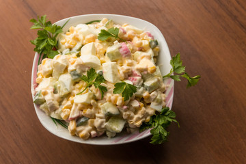 Salad with crab sticks, sweet corn, cucumber, eggs and mayonnaise