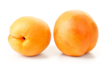 ripe juicy yellow apricots with leaves on a white table