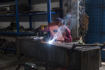 Welding or welder master weld the steel. Industrial weld worker. Sparks and smokes.