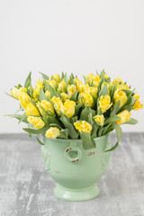Tulips of orange color in green vase. Big buds of multicoloured tulips. Floral natural backdrop. Bicolour tulips filled picture. Unusual flowers, unlike the others. Shallow focus.