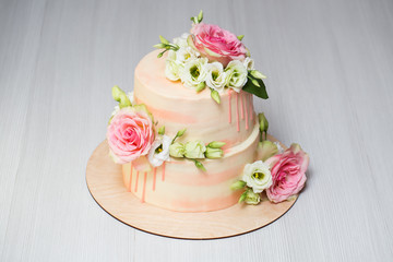 Obraz na płótnie Canvas Tiered cake with fresh flowers and macaroons