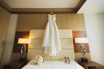 Beautiful wedding dress on hanger in room