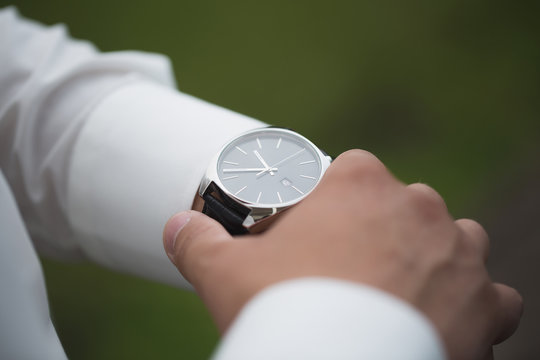 Close Up Of Businessman Looking At Watch On His Hand Outdoors, Free Space. Man In White Shirt Checking Time From Luxury Wristwatches. Watch On Hand. Groom Wedding Preparation