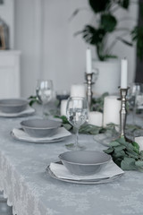 Wedding or festive table setting. Plates, wine glasses, candles and cutlery