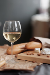 A glass of white wine and cheese on a blackboard
