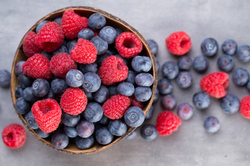Juicy and fresh blueberries with green mint on rustic gray table.