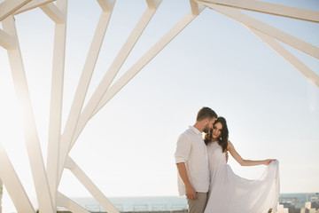 Man and woman posing. Geometric wooden structures. The bride and groom.