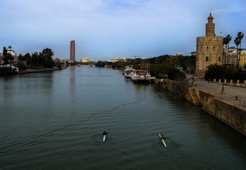 Obraz premium View of Golden Tower (Torre del Oro), Seville Tower and Guadalquivir river with canoeists. February 2018, Seville, Andalusia, Spain.