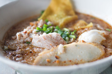 Spicy Noodles Tom Yum with pork on wooden table