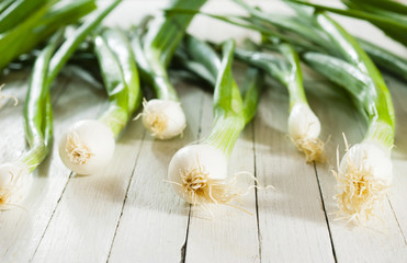 Spring onions on white wooden table