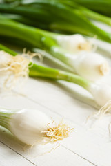 Spring onions on white wooden table