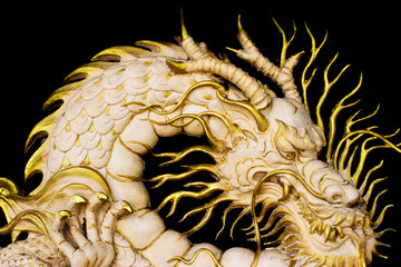 gold dragon stature with black background 