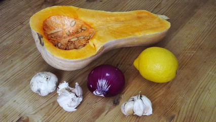 Pumpkin and vegetables on a wooden background.