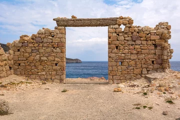 Foto op Plexiglas Rudnes De ruïnes van een oud gebouw in het pittoreske dorpje Firopotamos op het eiland Milos. Cycladen, Griekenland.