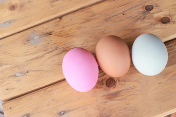 Eggs multi color on wooden background 