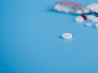 Sorted pharmaceutical vitamins, tablets and pills used in medicine for treatment lie on a light blue background
