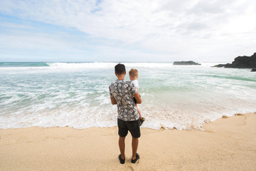 Father and Son Holding Hands Walking Together on the Beach