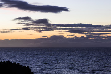 Colorful sky with intersting shaped clouds over the Atlantic Ocean at dawn
