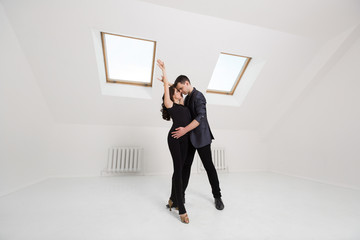 beautiful couple dancing bachata on white background in studio