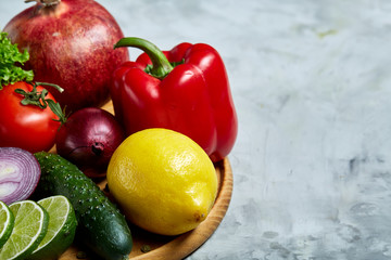 Ripe fresh fruits in a wooden plate on a light background, selective focus, close-up, top view