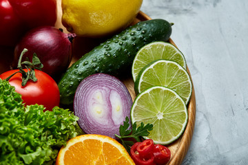 Ripe fresh fruits in a wooden plate on a light background, selective focus, close-up, top view