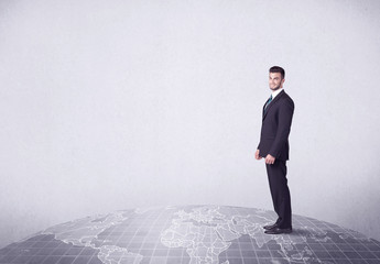 An elegant young male businessman standing on top of the world, pointing up concept with drawn earth map.