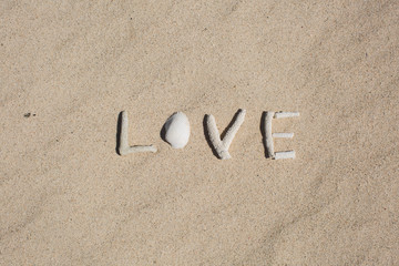word Love from corals on sand of tropical beach