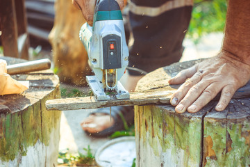 Man with protection gloves using an electric saw