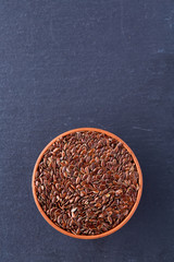 Fototapeta na wymiar Top view close-up picture of separate flax seed on dark grey background, macro.