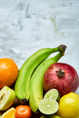 Ripe fresh fruits in a wooden plate on a light background, selective focus, close-up, top view