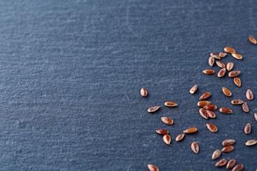 Top view close-up picture of separate flax seed on dark grey background, macro.