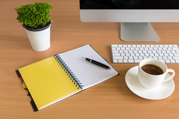 Office working wood desk with All in one Computer, note book, pen and coffee