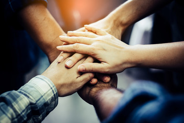 Obraz na płótnie Canvas Businessman and Businesswoman,Concept of teamwork: Close-Up of hands business team showing unity with putting their hands together.