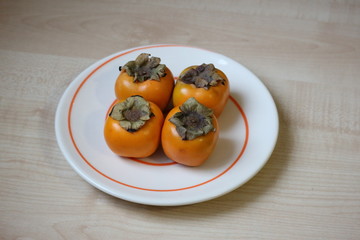 Four persimmons on the spiral plate