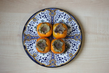 Four persimmons on the beautiful plate