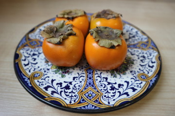 Four persimmons on the beautiful plate
