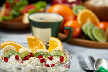 Breakfast still life with oatmeal porridge, fruits and coffee cup, top view, selective focus, shallow depth of field.