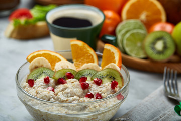 Breakfast still life with oatmeal porridge, fruits and coffee cup, top view, selective focus, shallow depth of field.
